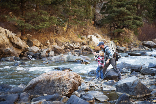Father and son fishing in stream