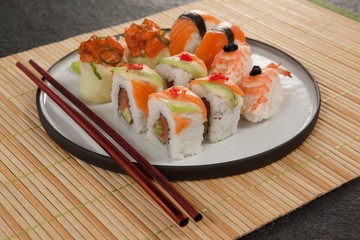 Assorted sushi set served with chopsticks on sushi mat