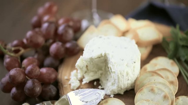Soft flavored creamy cheese with garlic and fine herbs on a wood board with crackers