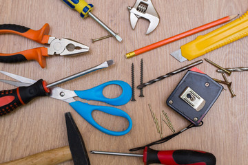 Tools for home repair and construction: hammer, screwdriver, nails, pliers, knife, ruler.