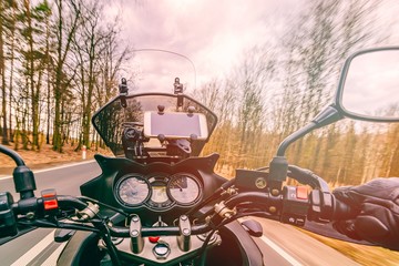 Naklejka premium Driving a motorcycle at spring at the asphalt road