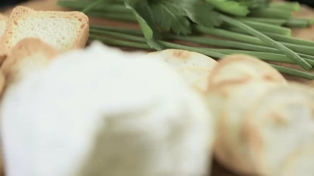 Soft flavored creamy cheese with garlic and fine herbs on a wood board with crackers