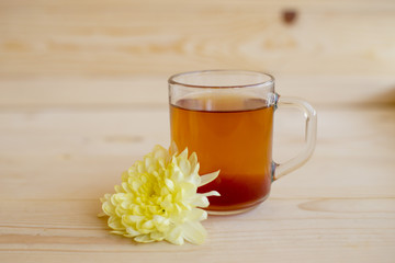 Black tea in a glass cup with tea leaves is on a wooden table. Tea, breakfast