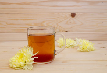 Black tea in a glass cup with tea leaves is on a wooden table. Tea, breakfast