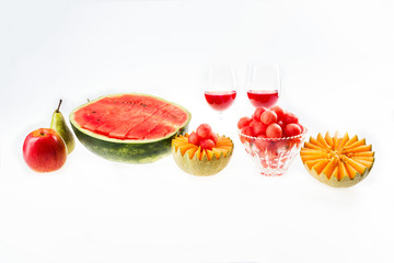 Dietary food, detox. Red watermelon and yellow melon, apple, pear and glasses with juice isolated on white background.