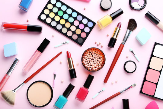 Different makeup cosmetics on a pink background