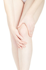 Woman touching her fatigued legs isolated on white, clipping path