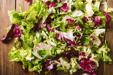 Salad mix on a wooden background. Ingredients for salad. Salad. Dietary food concept. Vegetable background. Background of salad