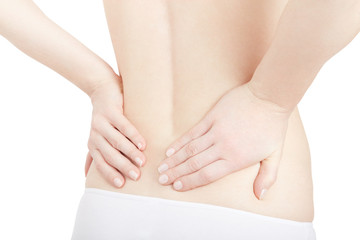 Young woman holds both hands on lower back, backache isolated on white, clipping path