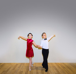 The young boy and girl posing at dance studio