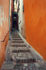 Narrow street of an old European city. Roussillon. France.Photo toned in retro style.