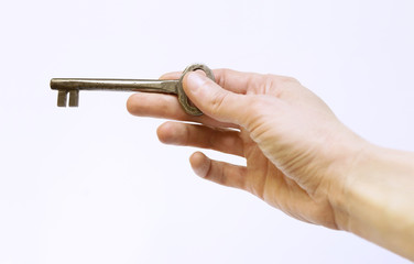 Vintage large key in human hand on white background