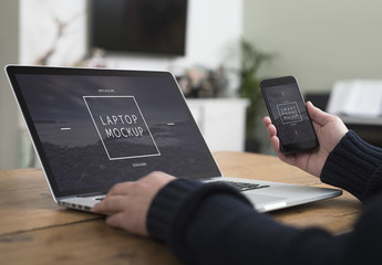 User with Smartphone and Laptop on Desk Mockup 3