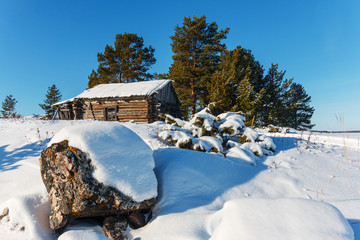 The old hut in the snow. Granite boulders in the foreground.