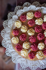 Beautiful multi colored decorated baked sweet tasty candy bar dessert party with happy people around, catering banquet table. macaroons