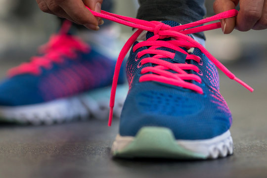 Running shoes - woman tying shoe laces. Woman getting ready for engage in the gym