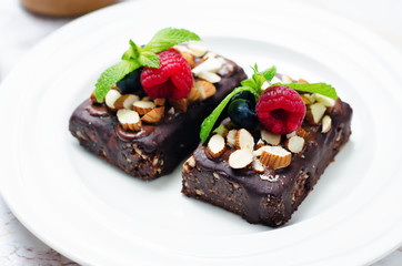 Raw vegan no bake chocolate dates almond brownies with chocolate frosting and berries