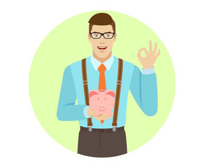 Businessman holding piggy bank and showing a okay hand sign