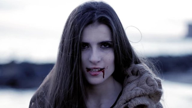 Scary female vampire smiling happy looking camera slow motion
