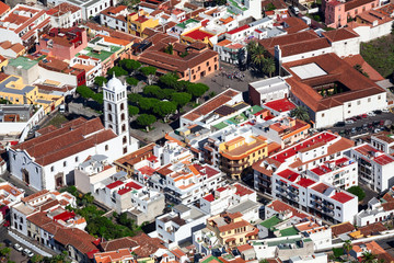Roofs of buildings of historical town of Garachico. Belltower of the Church of Saint Anna (Iglesia de Santa Ana). The Garachico is an ancient town on the north. Aerial view. Tenerife, Canary, Spain