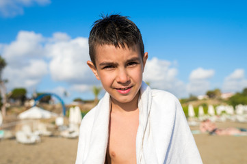 boy on the beach in a white towel