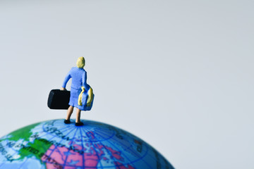 miniature traveler woman on the globe
