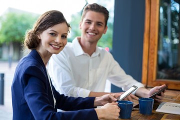 Businessman and woman using mobile phone 