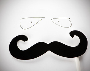 Disguise mustache over eyes drawn on white paper.