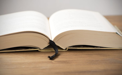 Open book on brown wooden table. Horizontal shoot.