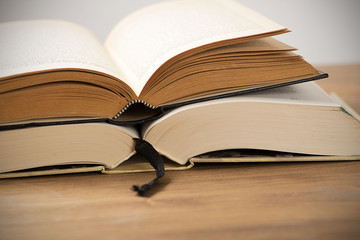 Two open books on brown wooden table..