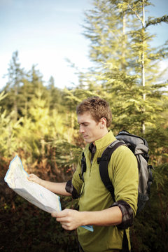 Young man with backpack looking at map