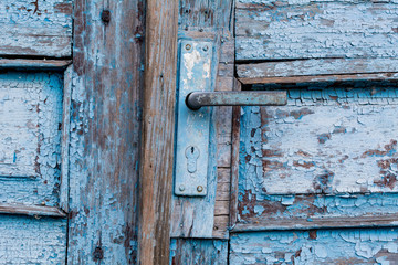 Old door handle close up. Metal handle and door lock of an old wooden blue door.