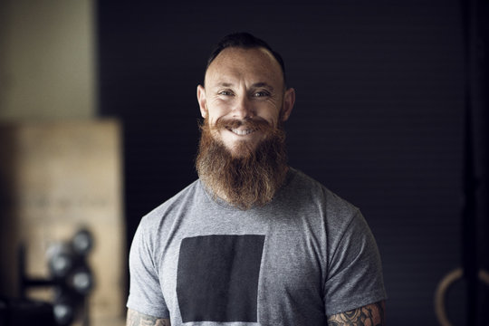 Portrait of smiling man with beard in gym