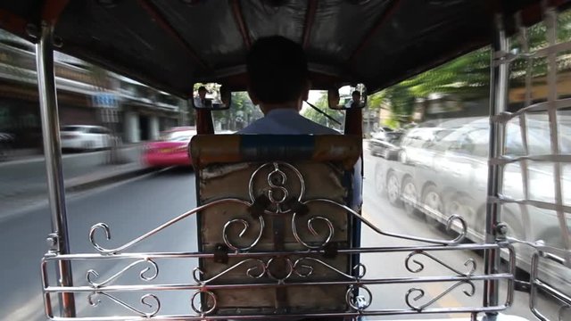 Tuk Tuk driving on street in Bangkok, Thailand. A popular three-wheeled taxi transport in Bangkok.