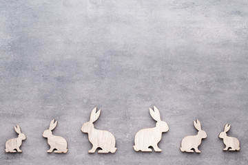 Handmade wood easter rabbits on wooden background.