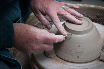 womans hands creating pottery objects in a ceramics workshop