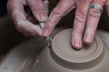 womans hands creating pottery objects in a ceramics workshop