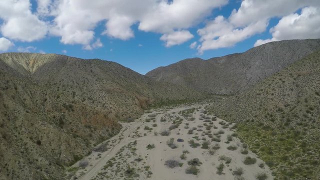 Scenic Aerial Flyover of Desert Valley, Mountains and Clouds