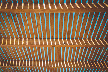 Board, ceiling background. Wooden roof with beams. Abstract architecture background, wooden interior construction, ceiling made of rough boards with light outside