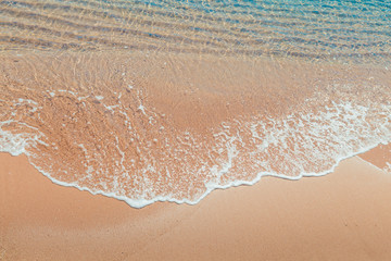 Wave on the beach. Soft Wave Of Blue Ocean On Sandy Beach. Background. Selective focus.