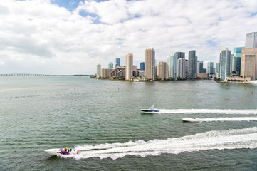 Obraz premium Aerial view of Miami skyscrapers with blue cloudy sky, boat sail