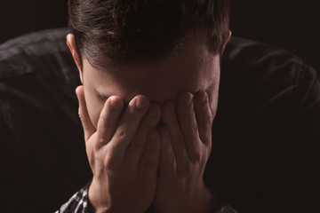 Handsome depressed man on black background