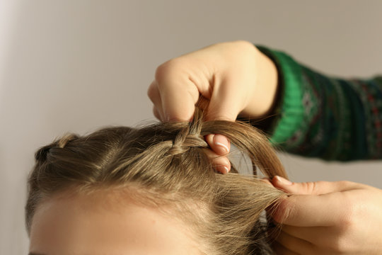 Hairdresser doing hairstyle to young woman