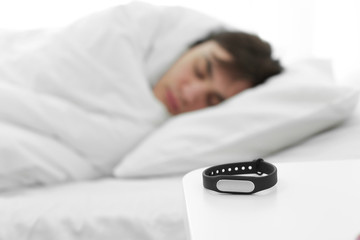 Obraz na płótnie Canvas Sleep tracker and blurred resting man on background