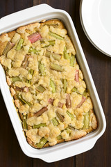 Freshly baked rhubarb crumble cake in baking dish, photographed overhead with natural light