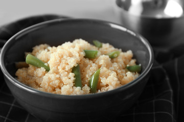 Cooked quinoa with French beans in black bowl