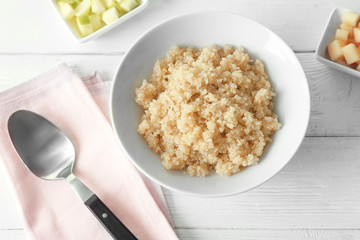 Bowl with cooked quinoa on kitchen table