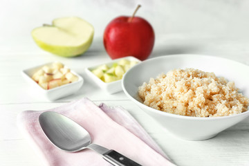 Bowl with cooked quinoa on kitchen table
