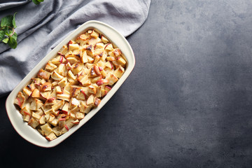 Tasty bread pudding with apples in baking dish on table