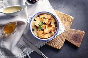 Delicious bread pudding with currant in bowl on table